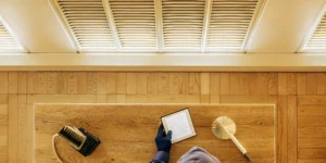 A technician inspecting a home's vents to get a quote for duct cleaning.