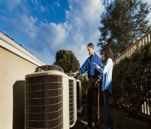 HVAC technician showing a high-efficiency air conditioner condenser to a San Antonio homeowner in a residential backyard